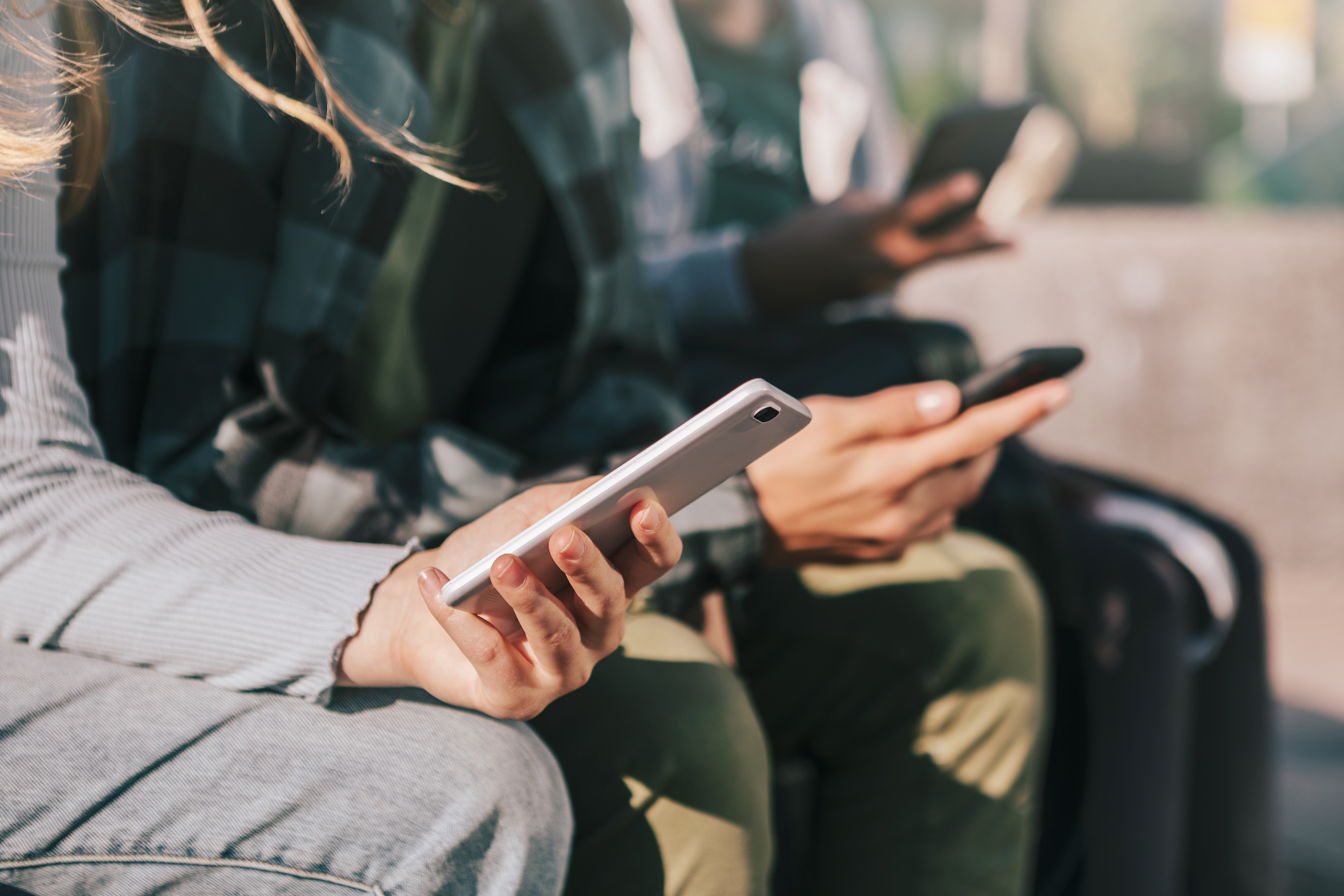 Detail of teenagers watching with their mobile phones